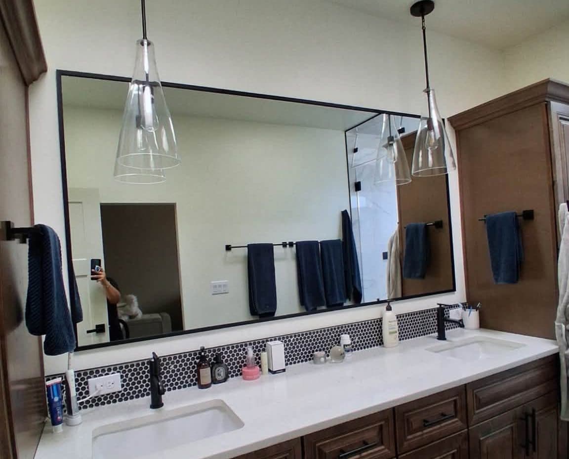 Bathroom vanity with a wide mirror and pendant lights after a house cleaning