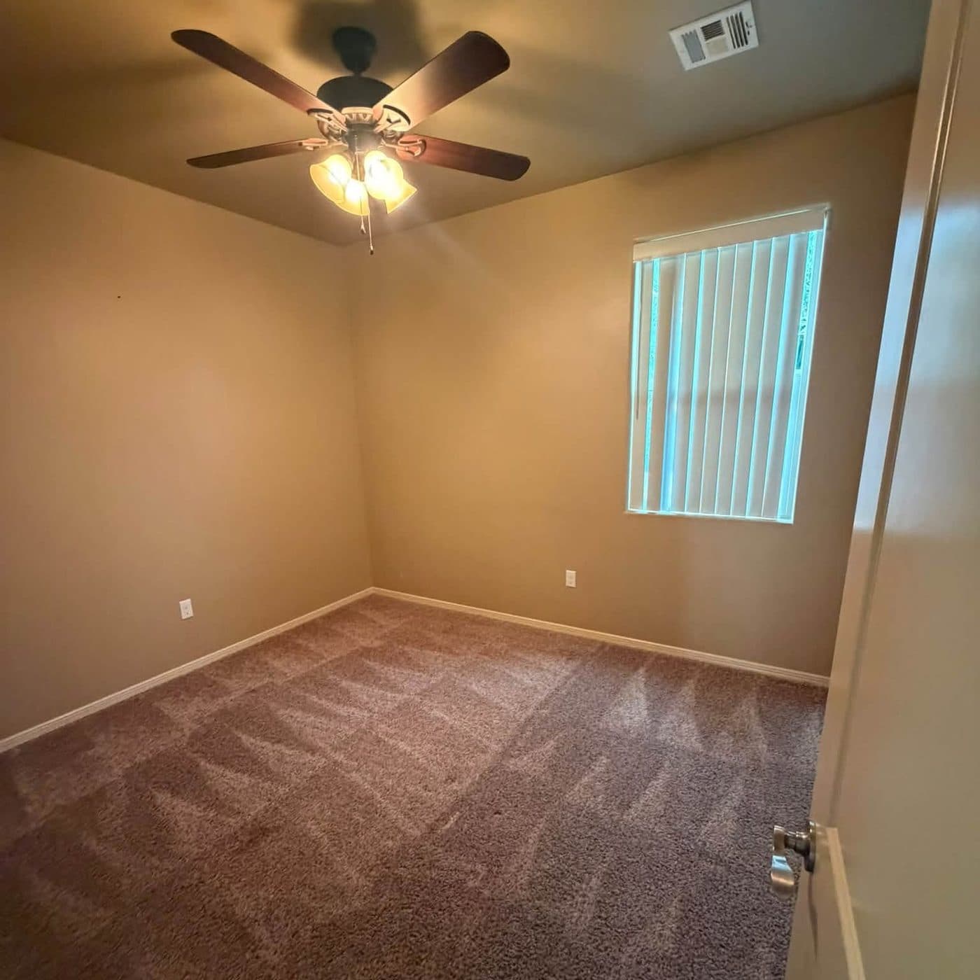 Empty carpeted bedroom, vacuumed, after a move-out cleaning