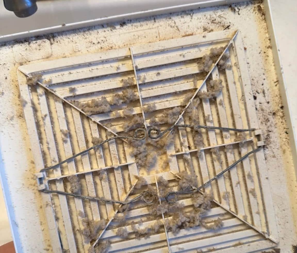 Ceiling vent grille clogged with dust before a deep cleaning