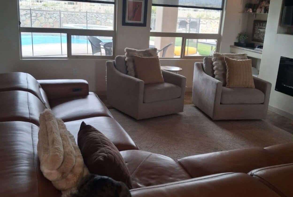 Living room with leather sofas and a view of the pool after a recurring house cleaning