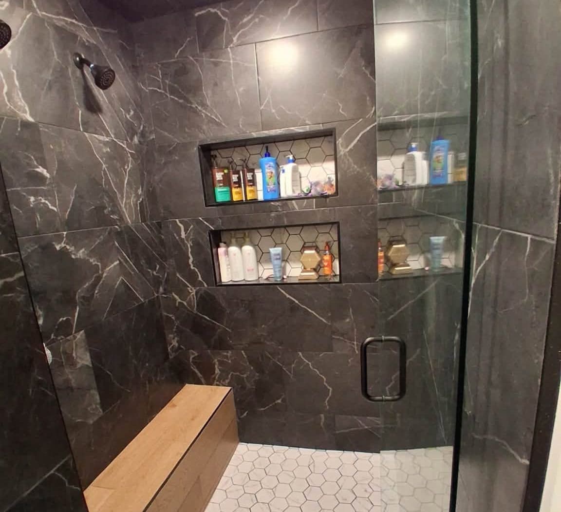 Dark marble walk-in shower with a glass door after a deep cleaning