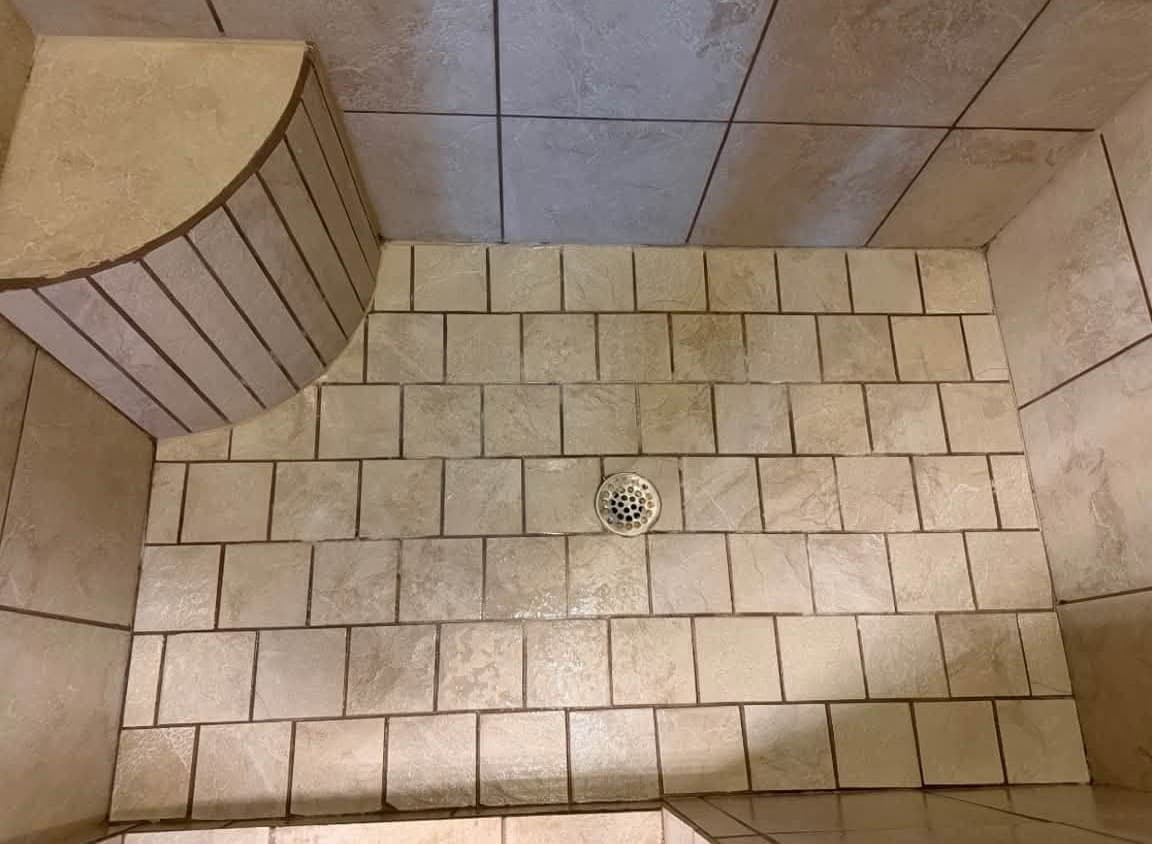 The same shower floor tile and grout after a deep cleaning by Kat's Cleaning Services