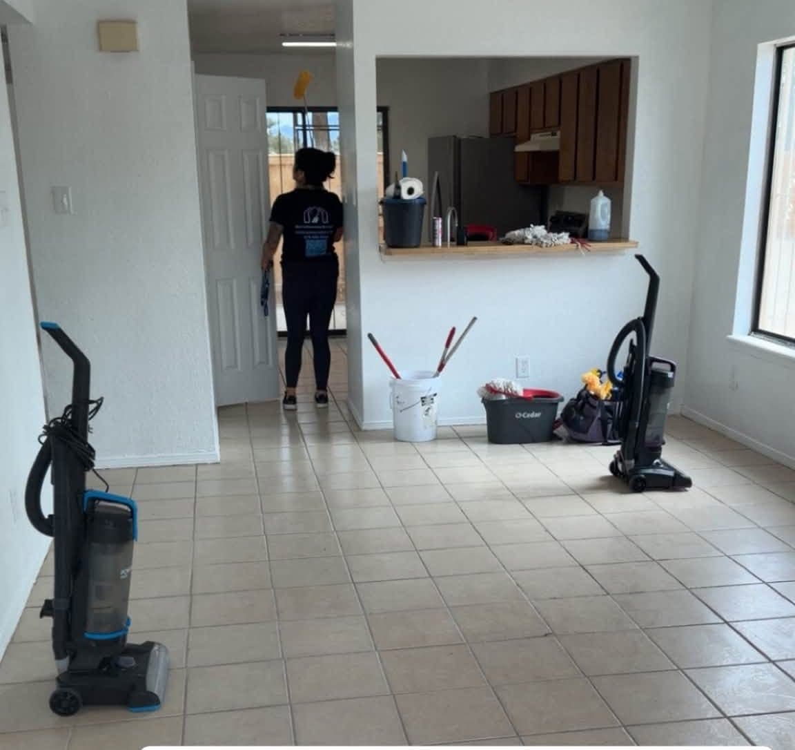A Kat's Cleaning Services team member with vacuums and supplies in an empty home on move-in cleaning day