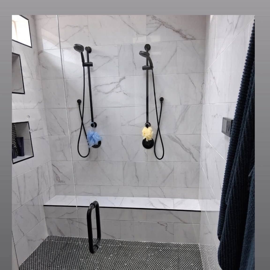 White marble walk-in shower with two shower heads after a deep cleaning